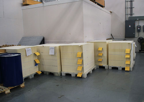 Rotated pallet of printed sheets ready to go back through the press. The yellow sheets separate the signatures.